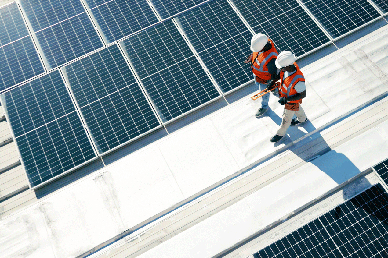 Deux personnes marchant sur un toit équipé de panneaux solaires