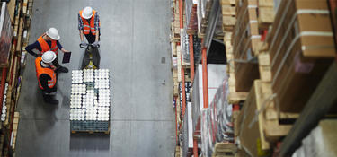 Three workers with a pallet jack in a Prologis warehouse