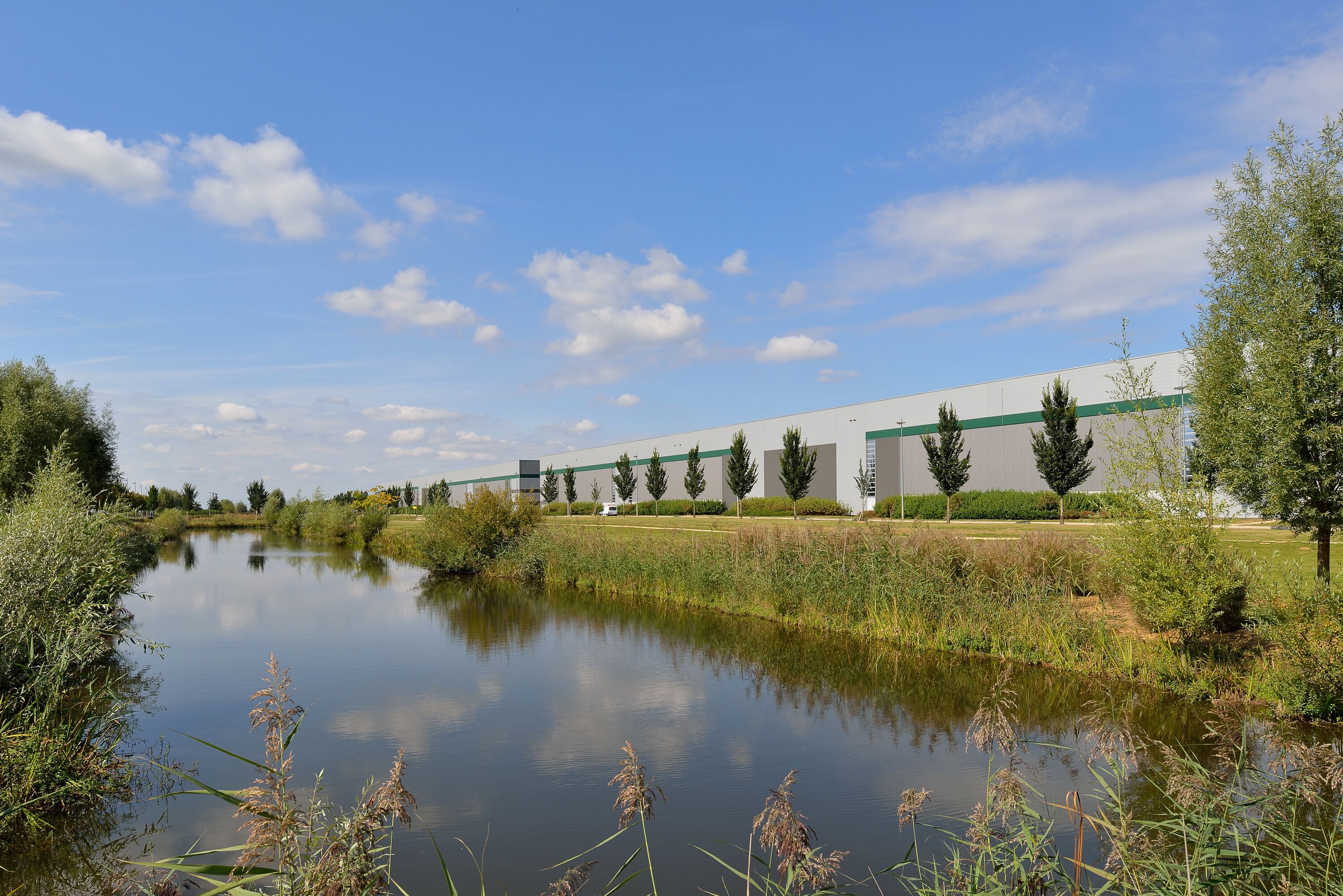 Een warehouse met bomen en een rivier in de omgeving Een warehouse met bomen en een rivier in de omgeving